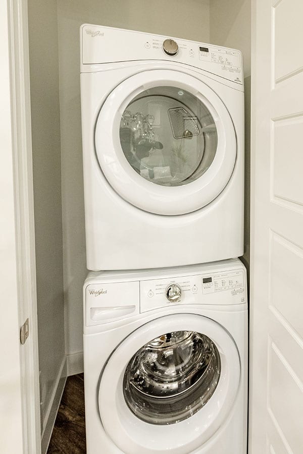 Stacked set of washer and dryer inside closet.