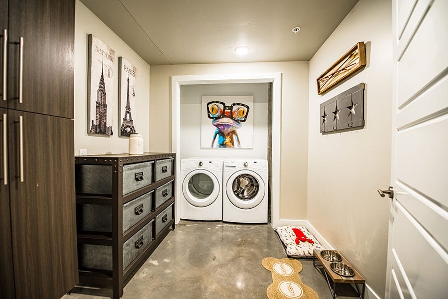 Laundry room with washer and dryer, large industrial style drawers, and polished concrete floors.