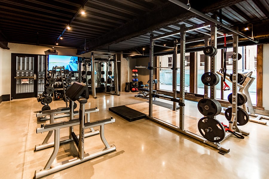 Fitness center weight area with lifting platform, squat rack and weight equipment.