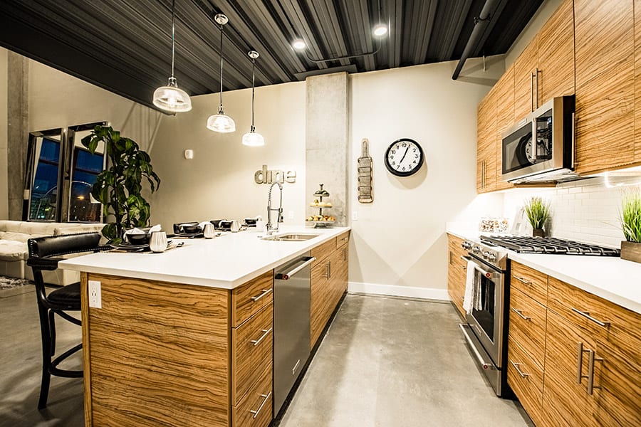 Kitchen with wooden cabinets, stainless steel appliances, and polished concrete floors.